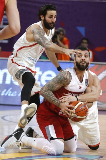 El escolta de la selección turca de baloncesto Goksenin Koksal  intenta avanzar con el balón ante la oposición de los jugadores españoles Ricky Rubio  y Marc Gasol. 