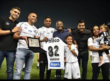El 14 de junio Santos organizó una despedida multitudinaria para Rodrygo. En el club desde los 9 años y su venta alivia las cuentas del club paulista. En la imagen Rodrygo con su familia recoge una placa y una camiseta conmemorativa del Santos.