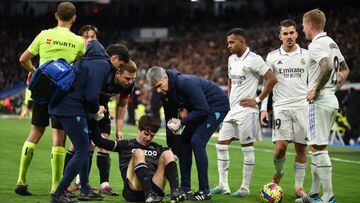 MADRID, SPAIN - JANUARY 29: Aritz Elustondo of Real Sociedad is helped to their feet after receiving medical treatment during the LaLiga Santander match between Real Madrid CF and Real Sociedad at Estadio Santiago Bernabeu on January 29, 2023 in Madrid, Spain. (Photo by Denis Doyle/Getty Images)