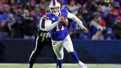 BUFFALO, NEW YORK - JANUARY 15: Josh Allen #17 of the Buffalo Bills runs the ball for a first down against the New England Patriots during the first quarter in the AFC Wild Card playoff game at Highmark Stadium on January 15, 2022 in Buffalo, New York.   