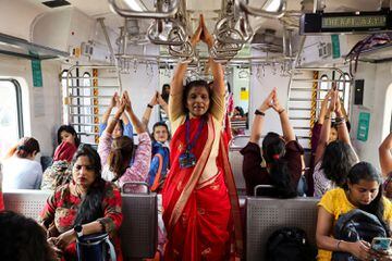 Las mujeres practican yoga en un tren local con motivo del Día Internacional de la Mujer en Mumbai, India.