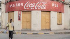 A man walks past a Coca Cola poster in Dire Dawa, Ethiopia, on October 23, 2022.