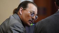 US actor Johnny Depp talks to attorney Ben Chew in the courtroom at the Fairfax County Circuit Courthouse in Fairfax, Virginia, on May 16, 2022. - Depp sued his ex-wife Amber Heard for libel in Fairfax County Circuit Court after she wrote an op-ed piece in The Washington Post in 2018 referring to herself as a "public figure representing domestic abuse." (Photo by Steve Helber / POOL / AFP) (Photo by STEVE HELBER/POOL/AFP via Getty Images)