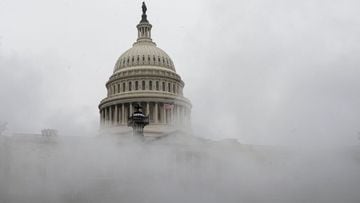 (FILES) In this file photo taken on December 16, 2020 mist from a steam pipe is seen coming from a grate near the US Capitol as a snow storm develops in Washington, DC. - US lawmakers on December 21 took the first step toward approving a $900 billion reli
