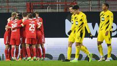 Union players (L) celebrate their teams opening goal during the German first division Bundesliga football match Union Berlin v Borussia Dortmund in Berlin on December 18, 2020. (Photo by ANNEGRET HILSE / POOL / AFP) / DFL REGULATIONS PROHIBIT ANY USE OF P