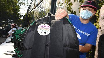 A volunteer organizes backpacks filled with school supplies for distribution to neighborhood families in need, August 14, 2020 in Los Angeles, California. - The back-to-school giveaway is being held as part of Adventist Health White Memorial hospital&#039