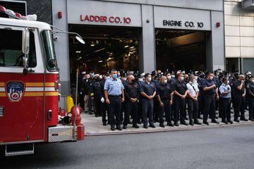 New York City firefighters pause outside of Engine Company 10 and Ladder Company 10 across from One World Trade Center this morning.