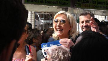 French far-right party Rassemblement National (RN) leader Marine Le Pen (C) meets people in an open air market in Marignane, near Marseille, while campaigning to support the candidacy of Franck Allisio (R) in the 12th constituency of the Bouches-du-Rhone 