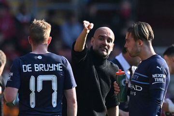 Manchester City's Spanish manager Pep Guardiola (C) speaks to Manchester City's English midfielder Jack Grealish (L) and Manchester City's Belgian midfielder Kevin De Bruyne