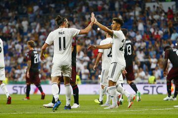 Bale (left) shares a high-five with Marco Asensio after scoring.