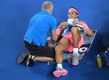 Spain's Rafael Nadal receives medical attention during their men's singles quarter-finals match against Croatia's Marin Cilic on day nine of the Australian Open tennis tournament in Melbourne on January 23, 2018. / AFP PHOTO / SAEED KHAN / -- IMAGE RESTRI