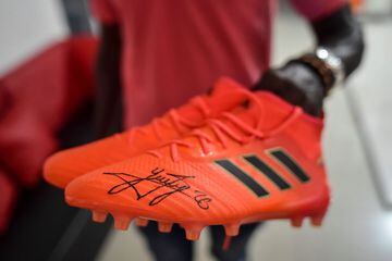 Colombian Seifar Apoza, coach of Colombian national football team player Yerry Mina when he played for Atletico Renacer club, shows boots signed by him during an interview with AFP in Guachené this week.