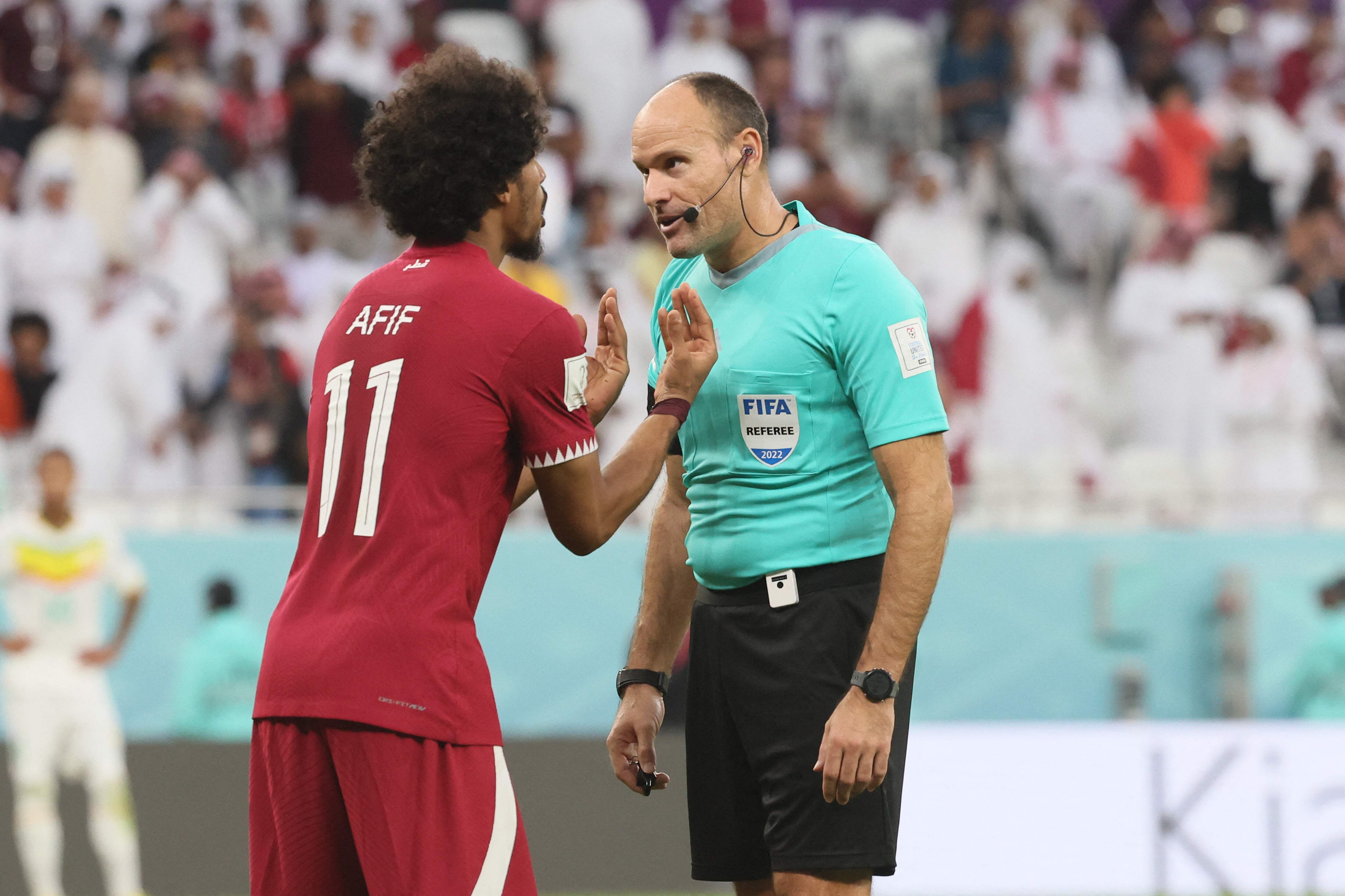 Qatar's forward #11 Akram Afif (L) appeals for a penalty to Spanish referee Antonio Mateu during the Qatar 2022 World Cup Group A football match between Qatar and Senegal at the Al-Thumama Stadium in Doha on November 25, 2022. (Photo by KARIM JAAFAR / AFP)