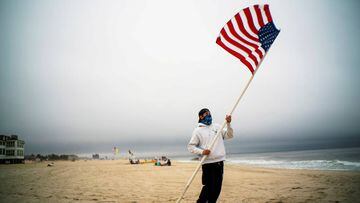 A beach guard removes the U.S. flag from its spot after a day of duty at Long Branch beach after New Jersey beaches were opened ahead of the Memorial Day weekend. 