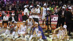 Real Madrid's players celebrate with the trophy and some fanily members after winning the Euroleague basketball final four final match between Olympiacos Piraeus and Real Madrid in Kaunas, on May 21, 2023. (Photo by PETRAS MALUKAS / AFP)