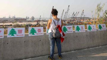 A woman looks at the names of the 191 people killed in the cataclysmic August 4 explosion, during a to mark one month since the blast, in the Lebanese capital Beirut on September 4, 2020. - The explosion piled on new misery for Lebanese already reeling fr