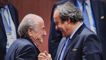 (FILES) This file photo taken on May 29, 2015 shows FIFA President Sepp Blatter (foreground-L) shaking hands with UEFA president Michel Platini after being re-elected following a vote to decide on the FIFA presidency in Zurich on May 29, 2015. Sepp Blatter won the FIFA presidency for a fifth time after his challenger Prince Ali bin al Hussein withdrew just before a scheduled second round. AFP PHOTO / MICHAEL BUHOLZER / AFP PHOTO / Michael BUHOLZER