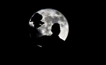 A supporter of Wydad Casablanca is silhouetted by the moon during the CAF Champions League final football match between Egypt's Al-Ahly and Morocco's Wydad Casablanca on November 4, 2017, at Mohamed V Stadium in Casablanca. 