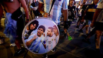 Soccer Football - FIFA World Cup Qatar 2022 - Doha, Qatar - November 25, 2022 An Argentina fan holds up his drum showing an image of Diego Maradona and Lionel Messi on the Doha Corniche REUTERS/Lee Smith