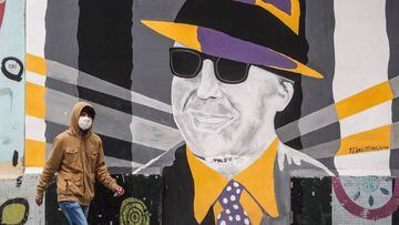 AME8522. BUENOS AIRES (ARGENTINA), 24/06/2020.-Un transe&uacute;nte camina frente a un mural de Carlos Gardel en Buenos aires hoy, mi&eacute;rcoles al cumplirse un nuevo aniversario de su muerte. Argentina recuerda, en el 85 aniversario de su muerte, a la leyenda del tango Carlos Gardel en una conmemoraci&oacute;n at&iacute;pica por el aislamiento impuesto para contener la pandemia del coronavirus. EFE/Juan Ignacio Roncoroni