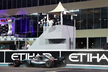Lewis Hamilton cruza la bandera a cuadros ondeada por Will Smith