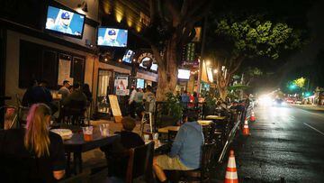 People view a television broadcast of Game 1 of the 2020 World Series between the Los Angeles Dodgers and the Tampa Bay Rays at an outdoor bar and restaurant, with seating on the street due to COVID-19, on October 20, 2020 in Los Angeles, California.