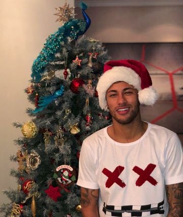 Neymar poses by the Christmas tree.