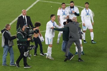 A pitch invader is apprehended as he approaches Real Madrid’s Cristiano Ronaldo after the game