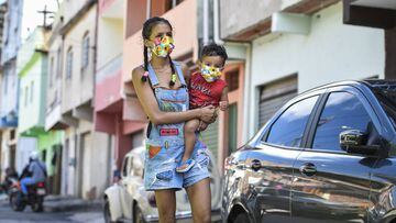 BELO HORIZONTE, BRAZIL - APRIL 13: Carolaine Reis and her son Miguel Alves, residents of the Aglomerado da Serra favela, wear a protective mask against the spread of the new Coronavirus (COVID-19) made by the seamstresses of the Remexe Favelinha studio, i