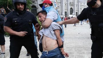 Police detain a man during clashes while fans wait to enter the Government House to pay tribute to late football legend Diego Armando Maradona in Buenos Aires, on November 26, 2020. - Diego Maradona&#039;s coffin arrived at the presidential palace in Buenos Aires for a period of lying in state, TV reports showed, following the death of the Argentine football legend aged 60 on November 25. Hundreds of people were already lining up to pay their respects to Maradona, who died while recovering from a brain operation, the images from sports channels TyC and ESPN showed. (Photo by ALEJANDRO PAGNI / AFP)