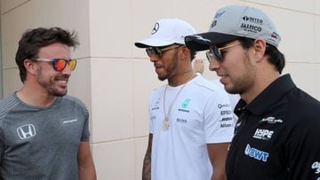 Mercedes&#039; British driver Lewis Hamilton (C) speaks with McLaren Honda&#039;s Spanish driver Fernando Alonso (L) and Force India&#039;s Mexican driver Sergio Perez (R) during a practise session as part of the Formula One Bahrain Grand Prix on April 13, 2017, at the Sakhir circuit in the desert south of the Bahraini capital, Manama. / AFP PHOTO / KARIM SAHIB