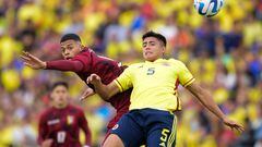 Venezuela's Kevin Kelsy (L) and Colombia's Kevin Mantilla jump for a header during their South American U-20 football championship final round match at El Campin stadium in Bogota, on February 12, 2023. (Photo by DANIEL MUNOZ / AFP)