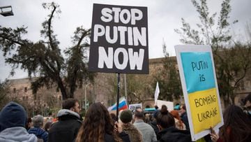 Demonstrators hold signs reading &quot;Putin is bombing Ukraine&quot; and &quot;Stop Putin Now&quot; during a protest against Russia&#039;s military operation in Ukraine, in Barcelona on February 26, 2022. 