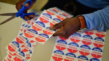 FILADELFIA, PA - 27 DE OCTUBRE: Un voluntario recorta calcoman&iacute;as de &quot;VOT&Eacute; HOY&quot; para los votantes que hacen cola fuera de un colegio electoral sat&eacute;lite el 27 de octubre de 2020 en Filadelfia, Pensilvania.
