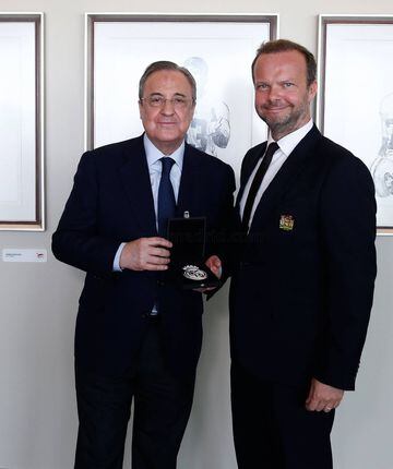 Florentino Pérez, presidente del Real Madrid, entrega a Ed Woodward, CEO del Manchester United, un pisapapeles del club blanco.