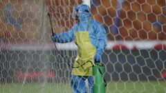 Soccer Football - Egyptian Premier League - Pyramids FC v Al Ahly - Cairo International Stadium, Cairo, Egypt - October 11, 2020 A person wearing protective clothing disinfects the goal posts REUTERS/Amr Abdallah Dalsh