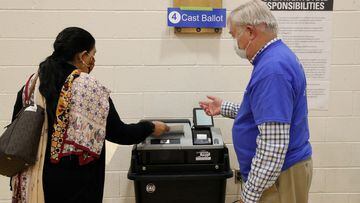 FILE PHOTO: A woman, who preferred not to give her name, gets verbal instructions from an Election Officer as she casts her ballot at a polling place at the Randolph Elementary School in Arlington, Virginia, U.S., November 2, 2021. REUTERS/Leah Millis/File Photo