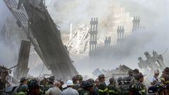 A group of firefighters stand on the street near the destroyed World Trade Centre in New York on September 11, 2001. 