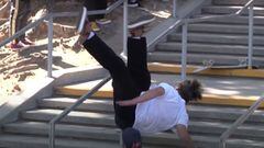 El skater Alex Midler cae con el skate en unas escaleras con una barandilla de doble kink. 