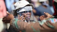 FILE PHOTO: A woman wears a protective face shield during food distribution, as South Africa starts to relax some aspects of a stringent nationwide coronavirus disease (COVID-19) lockdown, in Diepsloot near Johannesburg, South Africa, May 8, 2020. REUTERS