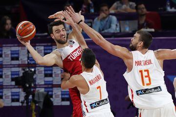 El escolta de la selección turca de baloncesto Melih Mahmutoglu intenta lanzar el balón ante la oposición de los jugadores españoles Juan Carlos Navarro y Marc Gasol.