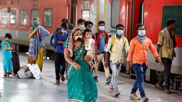Migrant workers and their families, who had left during a lockdown, walk at a platform after they returned from their home state of Uttar Pradesh, after authorities eased lockdown restrictions that were imposed to slow the spread of the coronavirus diseas