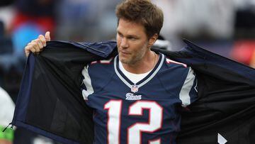 FOXBOROUGH, MASSACHUSETTS - SEPTEMBER 10 Former New England Patriots quarterback Tom Brady takes off his rain coat during a ceremony honoring Brady at halftime of New England's game against the Philadelphia Eagles at Gillette Stadium on September 10, 2023 in Foxborough, Massachusetts.   Adam Glanzman/Getty Images/AFP (Photo by Adam Glanzman / GETTY IMAGES NORTH AMERICA / Getty Images via AFP)