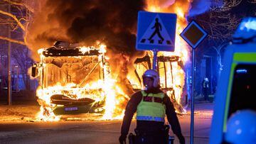 A police personnel stands near a burning bus after a demonstration organised by Rasmus Paludan, leader of Danish far-right political party Hard Line turned violent, in Rosengard , Malmo, Sweden April 16, 2022. Picture taken April 16, 2022. Johan Nilsson/TT News Agency/via REUTERS      ATTENTION EDITORS - THIS IMAGE WAS PROVIDED BY A THIRD PARTY. SWEDEN OUT. NO COMMERCIAL OR EDITORIAL SALES IN SWEDEN.