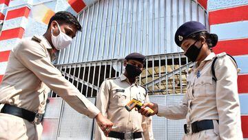 A security personnel (R) of Netaji Subhash Chandra Bose central jail checks the temperature of duty policemen during a government-imposed nationwide lockdown as a preventive measure against the COVID-19 coronavirus in at Netaji Subhash Chandra Bose centra