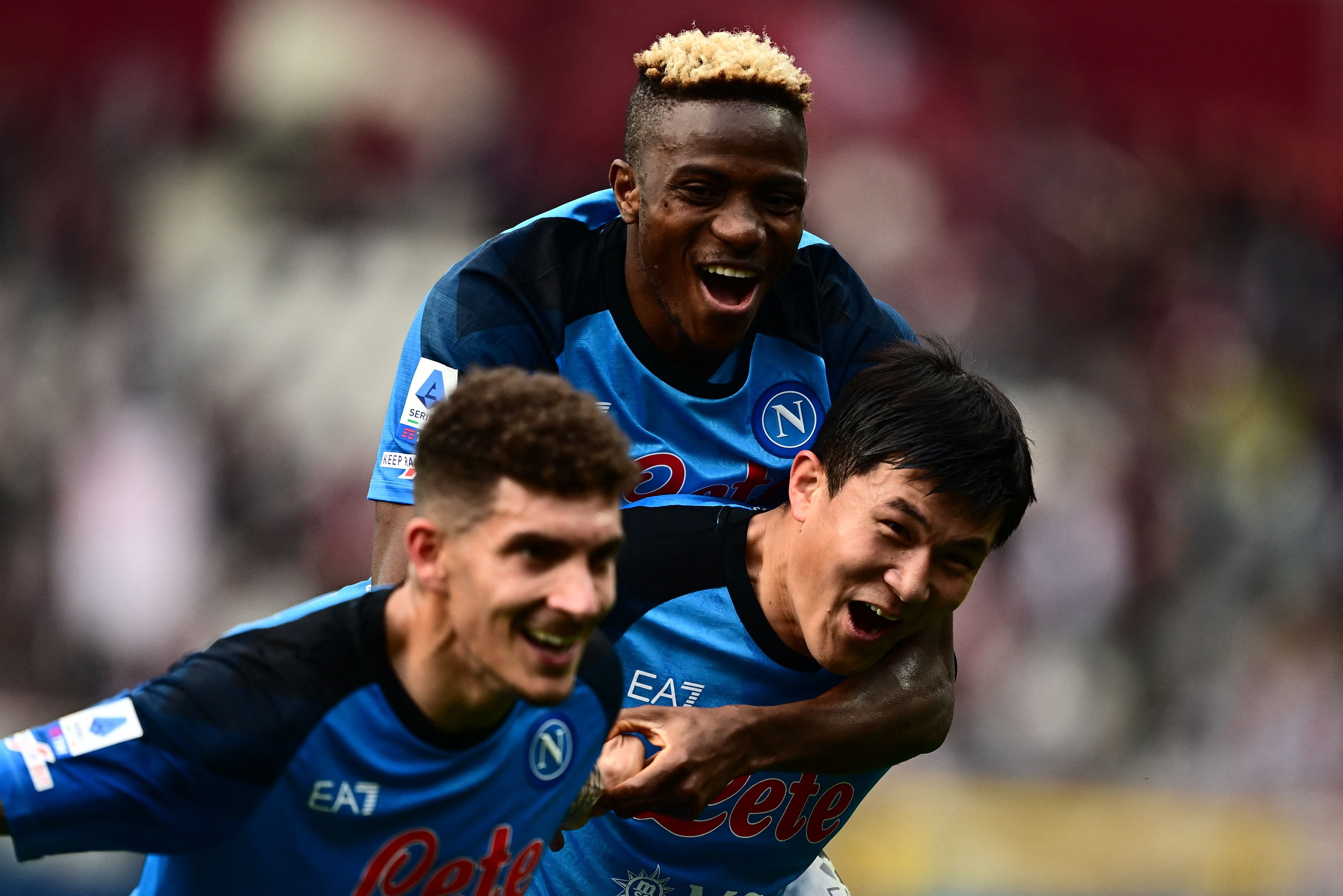 Napoli's South Korean defender Min-jae Kim (R) carries Napoli's Nigerian forward Victor Osimhen as they celebrate with Napoli's Italian defender Giovanni Di Lorenzo at the end of the Italian Serie A football match between Torino and Napoli on March 19, 2023 at the Olympic stadium in Turin. (Photo by Marco BERTORELLO / AFP)