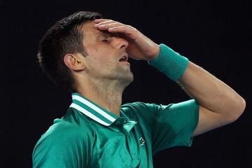 (FILES) This file photo taken on February 16, 2021 shows Serbia's Novak Djokovic reacting after losing a point against Germany's Alexander Zverev during their men's singles quarter-final match on day nine of the Australian Open tennis tournament in Melbou