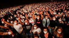 People wearing protective masks attend a concert of &quot;Love of Lesbian&quot; at the Palau Sant Jordi, the first massive concert since the beginning of the coronavirus disease (COVID-19) pandemic in Barcelona, Spain, March 27, 2021. REUTERS/Albert Gea  