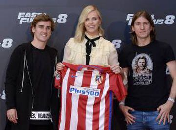 Charlize Theron (C) receives an Atletico de Madrid shirt from Atletico de Madrid players Antoine Griezmann (L) and Filipe Luis (R) during a photocall for 'Fast and Furious 8' at the Villamagna Hotel on April 6, 2017 in Madrid, Spain.