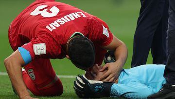 Iran's defender #03 Ehsan Hajsafi (L) speaks with his goalkeeper #01 Alireza Beiranvand following a crash of heads with Iran's defender #19 Majid Hosseini during the Qatar 2022 World Cup Group B football match between England and Iran at the Khalifa International Stadium in Doha on November 21, 2022. (Photo by Adrian DENNIS / AFP)